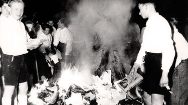 Members of the Nazi Youth participate in burning books, Buecherverbrennung, in Salzburg, Austria, on April 30, 1938. The burning of books that are condemned as Jewish-Marxist is a vast anti-semitic activity of Nazi Germany. | Bild: picture alliance / akg-images | akg-images
