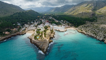 Spain, Balearic Islands, Cala Sant Vicenc, Aerial view of coastal town with mountains in background. | Bild: picture alliance / Westend61 | Martin Moxter