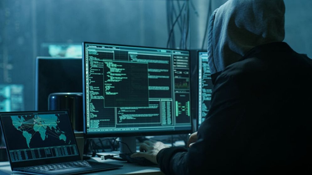 Ein Mann sitzt mit Kapuze vor einem PC und hackt. Bei einem großen Cyberangriff sind Daten von Krankenhäusern und sozialen Einrichtungen in ganz Schwaben gestohlen worden. (Symbolbild) | Bild: stock.adobe.com/Gorodenkoff